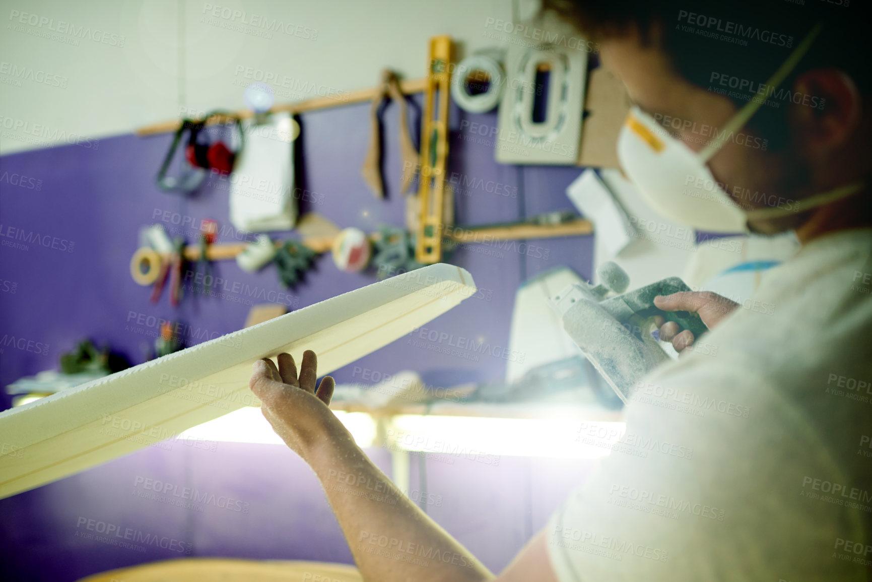 Buy stock photo Hands, man and sanding foam in workshop for surfing equipment, manufacturing and design process. Surfboard shaper, artisan and machine in garage for quality production, custom craft or small business