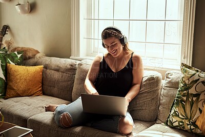 Buy stock photo Computer, headphones and woman on sofa and music, happy work from home for mental health in apartment. Young person relax on couch and listening to audio technology, electronics and working on laptop