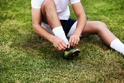 Buy stock photo Man, hands or tying laces with shoes on grass field for sport, running or workout preparation. Male person, legs or tie soccer boots for game, match or getting ready for football practice or training