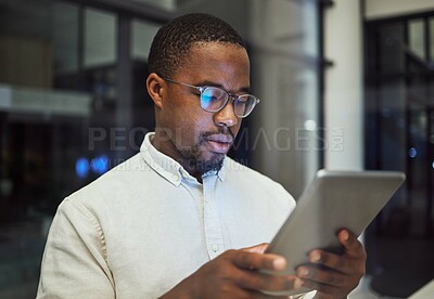Buy stock photo Tablet research, night planning and businessman working on email on the internet while in a dark office at work. Corporate African employee reading communication online on tech while doing overtime