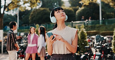 Buy stock photo Headphones, phone and thinking with Japanese student in park for streaming, University campus and online playlist. Music, vision and education podcast with woman and mobile in Japan for college