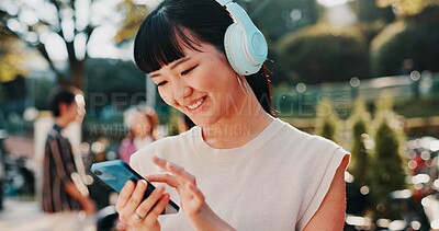 Buy stock photo Music, phone and student with Japanese woman in park for streaming, University campus and online playlist. Headphones, radio and education podcast with person and mobile in Japan outdoor for college