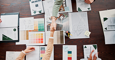 Buy stock photo Interior designer, documents and shaking hands with partnership in office for renovation offer, deal and contract. Above, paperwork and people with handshake for design proposal approval or agreement