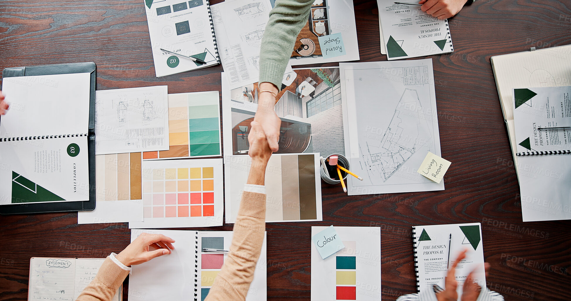 Buy stock photo Interior designer, documents and shaking hands with partnership in office for renovation offer, deal and contract. Above, paperwork and people with handshake for design proposal approval or agreement