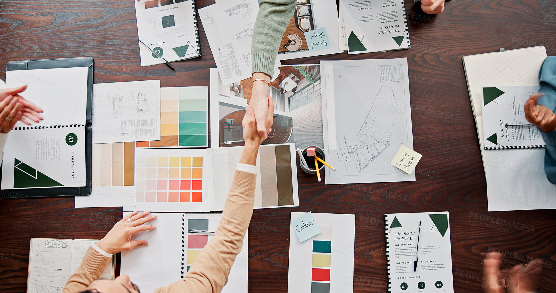 Buy stock photo Creative, applause and shaking hands with partnership in office for renovation offer, deal and contract. Above, documents and people with handshake for interior designer approval and design agreement