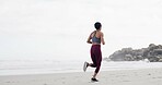 Woman, running and back at beach, training and fitness with space, sky and outdoor with routine. Person, workout and exercise for wellness, cardio challenge and jog by ocean for health in New Zealand