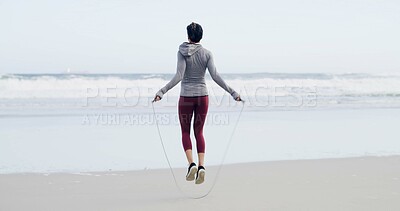Buy stock photo Beach, fitness and skipping with sports woman outdoor for cardio training or workout in morning. Exercise, jump rope and view of horizon with athlete person at ocean or sea for challenge from back