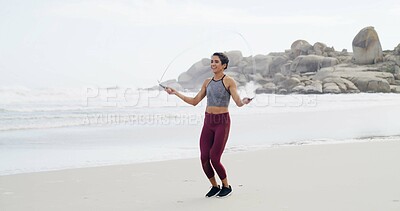 Buy stock photo Fitness, skipping and smile with woman on beach for cardio training or workout in morning. Exercise, jump rope and view of horizon with happy athlete person at ocean or sea for health challenge