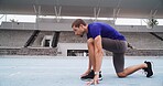 Man, athlete and preparation with start line on stadium track for sprint, race or training lap. Active, male person or runner getting ready to begin for sport competition, distance running or fitness