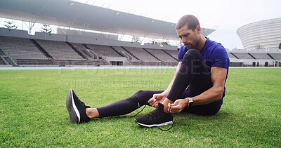 Buy stock photo Fitness, footwear and tie with man on field in stadium for start of cardio training or workout. Exercise, laces and shoes with athlete or runner getting ready for competition or sports in arena