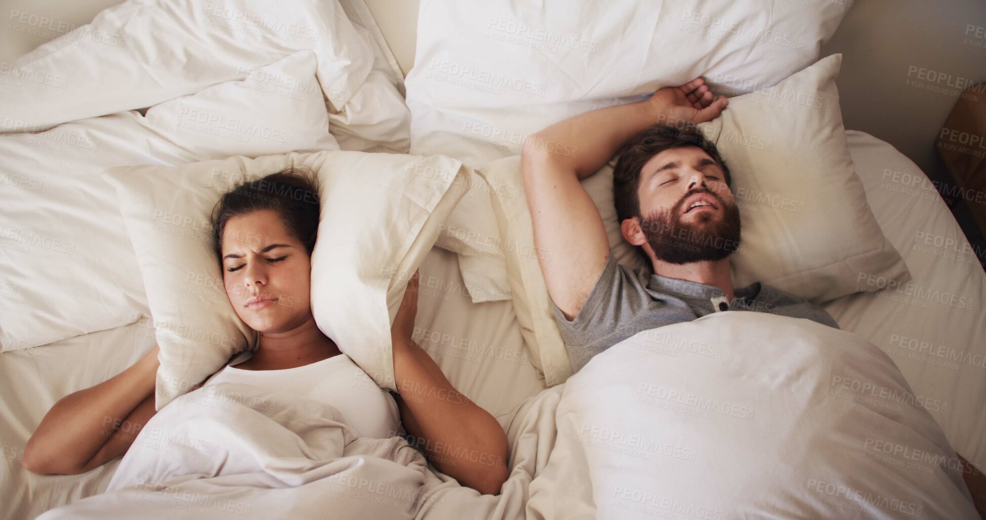 Buy stock photo Couple, bed and woman with man snoring, loud or noise with frustrated partner in home. Person with sleep apnea, above angry or annoyed wife for sleepless and awake, upset and cover ears at house 
