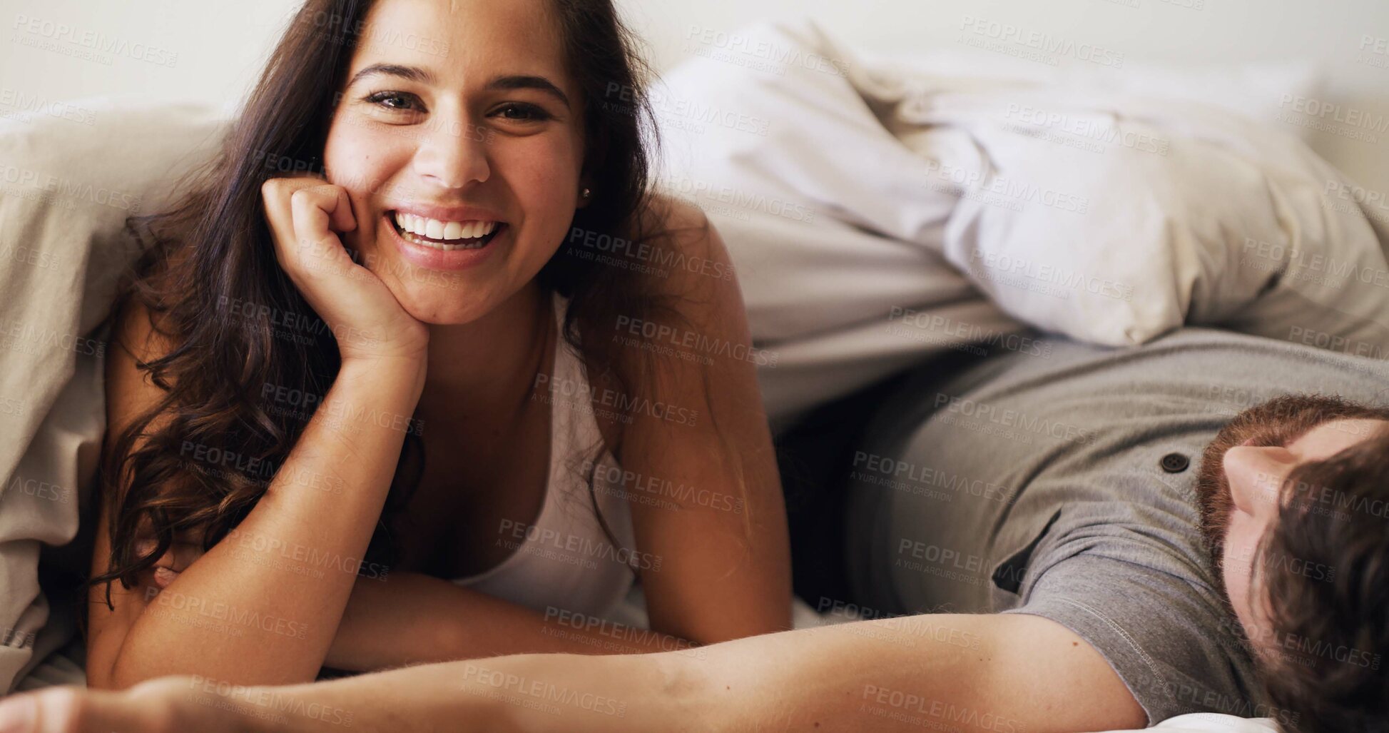 Buy stock photo Happy woman, relax and wake up with bed in home for morning, comfort or peaceful holiday. Portrait, female person or lying awake with man asleep in bedroom for rest, nap or weekend together in house
