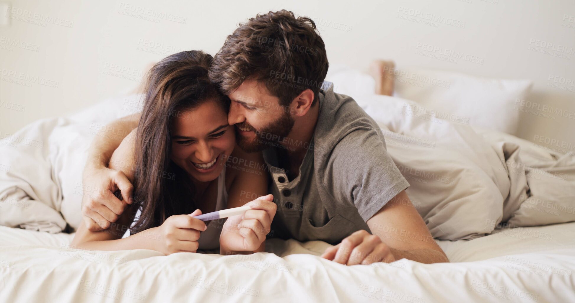 Buy stock photo Happy, love and couple with pregnancy test on bed for future, family or baby together in home. Smile, bonding and man with woman for positive pregnant kit with excitement in marriage in bedroom.