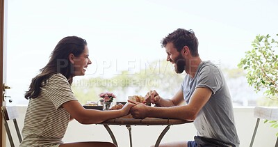 Buy stock photo Breakfast, holding hands and laughing with couple on balcony of home together for bonding. Funny, love and morning with happy people outdoor at apartment for anniversary, honeymoon or romance