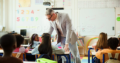 Buy stock photo Education, children and teacher in classroom with help, project advice and individual assessment. Man, educator and student in elementary school for development, study tips and creative curriculum