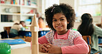 Building blocks, ;earning and portrait of student girl at desk in classroom of elementary school. Education, smile and study with happy child in class for coordination or motor skills development