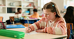 Girl, education and writing test in classroom with problem solving, development or assessment at academy. Child, paper and solution for question with language, learning and quiz at elementary school