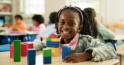 Buy stock photo Building blocks, portrait and smile of student girl at desk in classroom of elementary school. Education, learning and study with happy child in class for coordination or motor skills development
