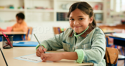 Buy stock photo Portrait, writing and happy girl in classroom for learning education or nursery with students. Kindergarten, academy and female kid at school for child development, assessment or knowledge evaluation