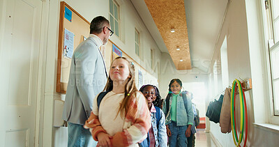 Buy stock photo Walking, children and teacher at school for welcome, education development or support. Encourage, greeting or group of happy kids with man for learning, scholarship and morning in hallway at academy