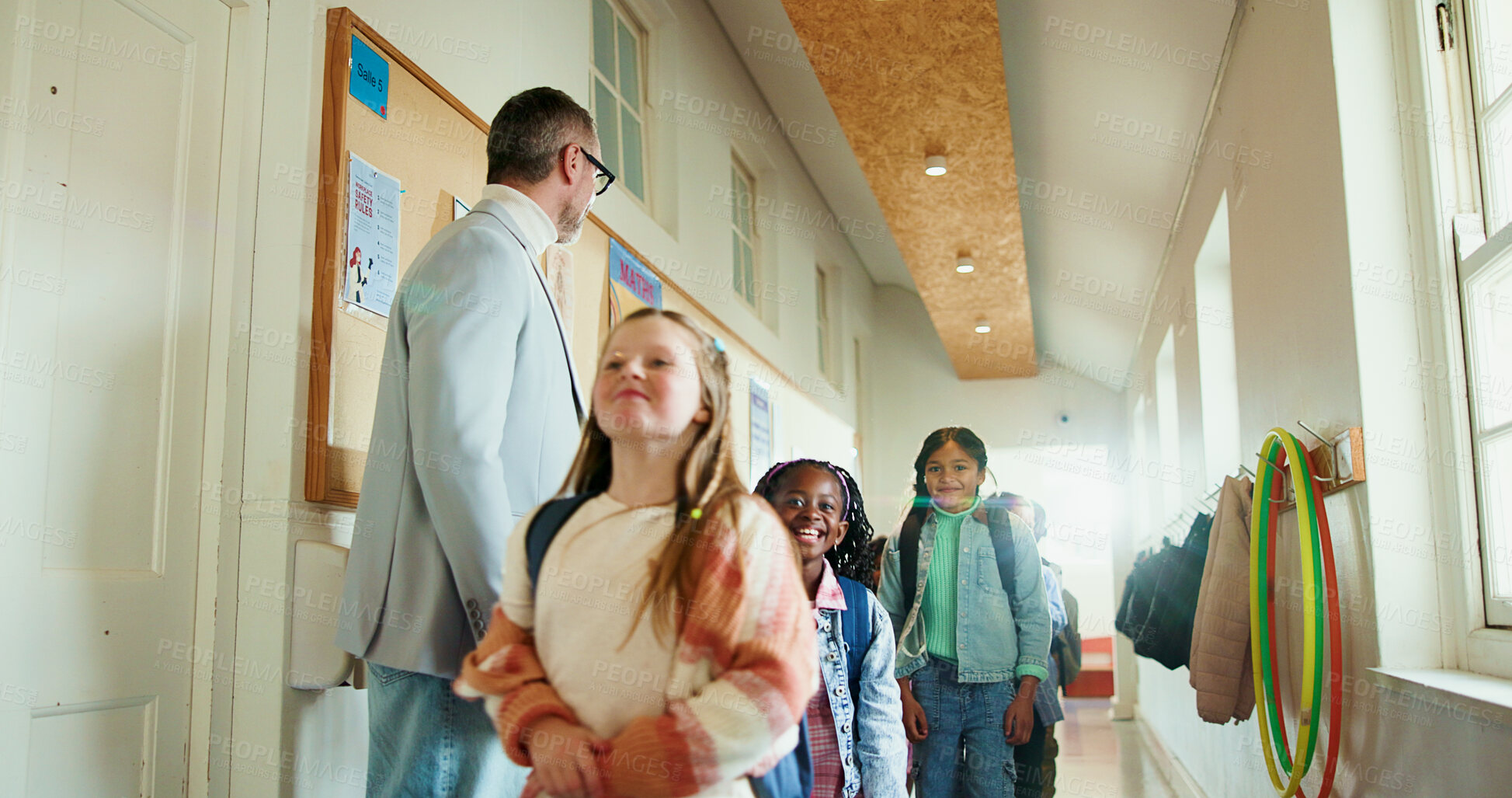 Buy stock photo Walking, children and teacher at school for welcome, education development or support. Encourage, greeting or group of happy kids with man for learning, scholarship and morning in hallway at academy