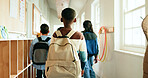 Back, children and students with backpack in lobby at preschool, education and lunch break. Boy, kids and walking to classroom for learning, group studying and scholarship for knowledge growth