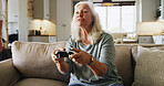 Senior, woman and gaming with console controller for video games or online entertainment in home. Elderly, female person or gamer with joystick on couch for old arcade subscription or competition