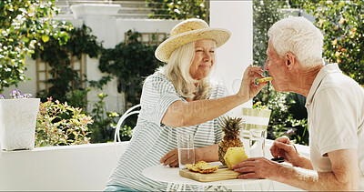 Buy stock photo Senior couple, feeding or fruit with breakfast in garden for healthy snack, water or pineapple. Elderly, man and woman with smile, drink or natural organic food for retirement together in backyard