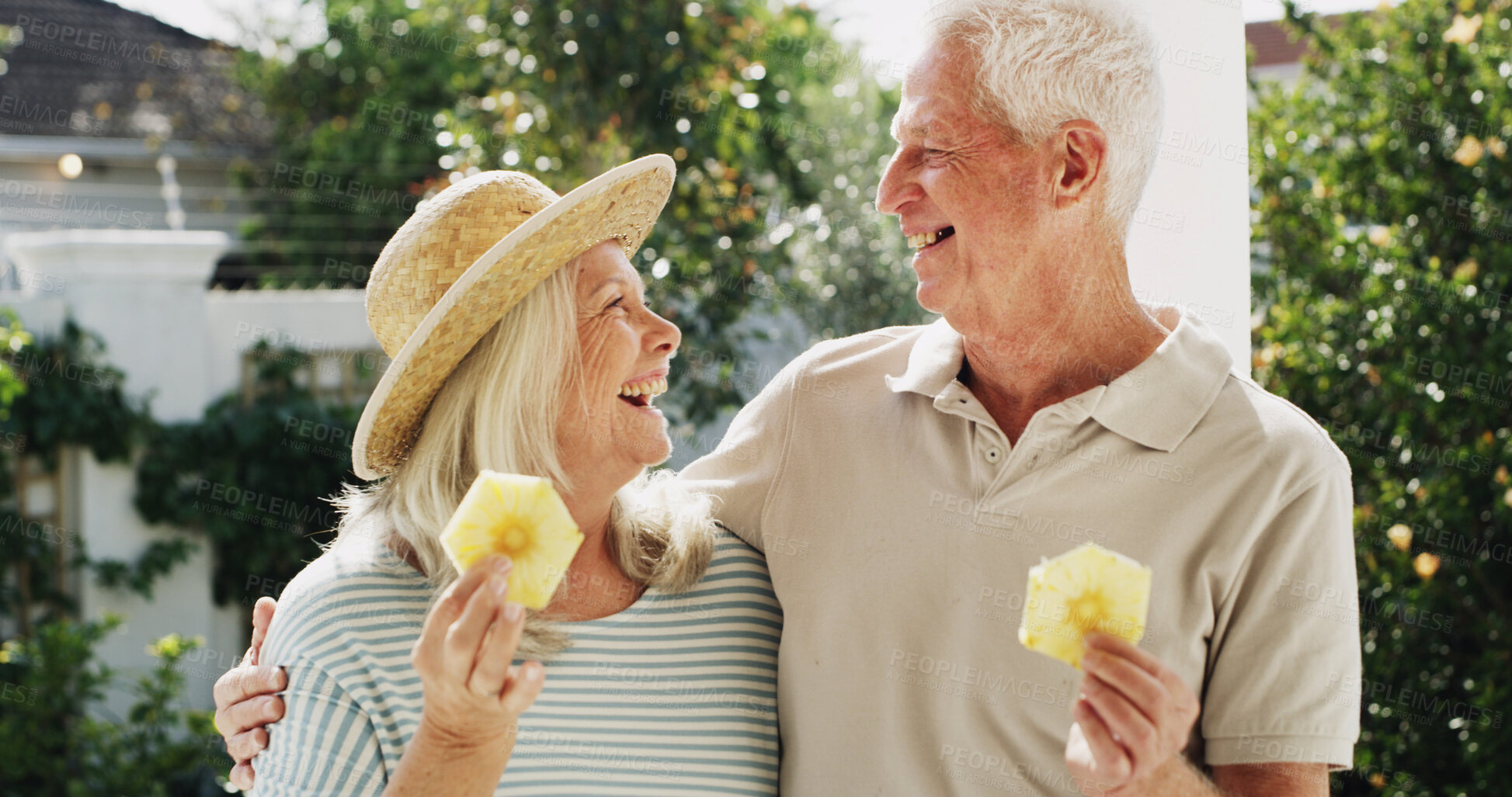 Buy stock photo Outdoor, bonding and senior couple with fruit, patio or laughing on break, wellness or healthy diet. Home, old woman and elderly man with pineapple on weekend, romance or people with humor for joke