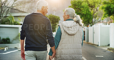 Buy stock photo Senior couple, holding hands and walking with back in neighborhood for romance, date or bonding. Elderly, man and woman strolling in street or road for mobility, commitment or retirement together