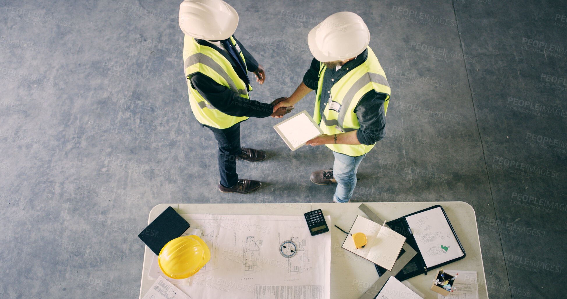 Buy stock photo Above, construction worker or people with handshake for deal, agreement or mockup space. Top view, architect or team shaking hands for collaboration, development or safety approval with tablet screen
