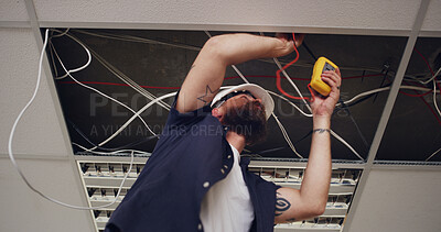 Buy stock photo Electrician, man and meter with light wires for construction, remodeling project or renovation. Handyman, contractor repair and low angle maintenance for electric, circuit or installation for office