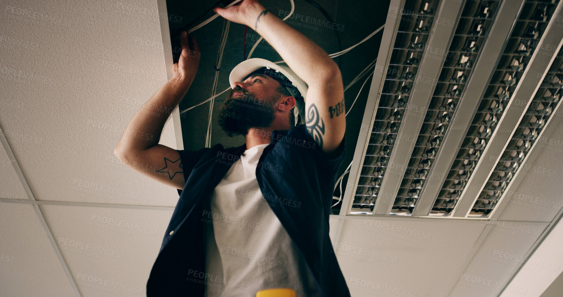 Buy stock photo Electricity, repair or man with cable in roof, light installation or maintenance check for safety. Below, electrician or person with wire for led fixture, power inspection or connection in ceiling.