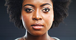 Serious, black woman and portrait with eyes in studio for awareness on a dark background. Face, female person or African model with facial expression or afro for mental health, ethnicity or trauma