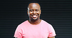 Happy, black man and portrait with fashion in studio for positive attitude on a dark background. Face, male person or African model with smile, pink tshirt or friendly expression on mockup space