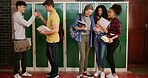 Teenagers, group and people at high school for story, gossip or learning at recess. Education, happy friends or students in conversation on break by lockers with fist bump, chat and laugh at campus