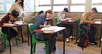 Test, high school and teacher walking in classroom for assessment, exam and quiz supervision. Teaching, academy and woman with students writing assignment for education, learning and lesson progress