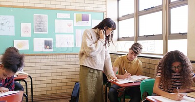 Buy stock photo High school, classroom and teacher with student for help with test, assignment and exam question. Academy, teaching and woman with teenager writing assessment for education, learning and development