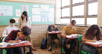 Buy stock photo High school, supervision and teacher walking in classroom for assessment, exam and quiz. Teaching, academy and woman with students writing assignment for education, lesson and learning progress