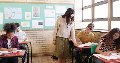 Buy stock photo Test classroom and teacher with student for help with studying, assignment and exam question. High school, teaching and woman with teenager writing assessment for education, learning and development