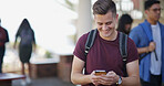 Happy, university and man with phone on campus for social media, internet and networking at college. School, space and student on smartphone for online chat, website and class schedule for learning