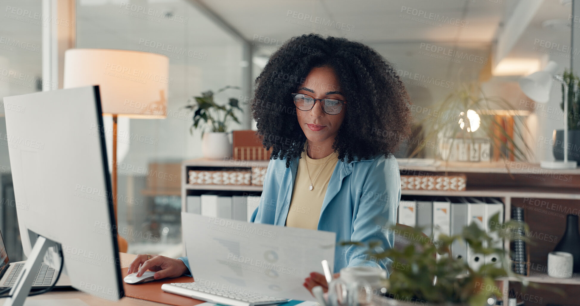 Buy stock photo Reading, paperwork and woman with computer in office, serious or working late for data entry on web. Online, accountant and African person with glasses for financial report, graphs and tech at night