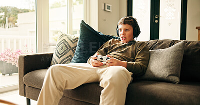 Buy stock photo Home, video game and boy with controller, kid and entertainment with challenge. Apartment, headset and child on couch, online contest or audio with esports, click and relax with hobby or subscription
