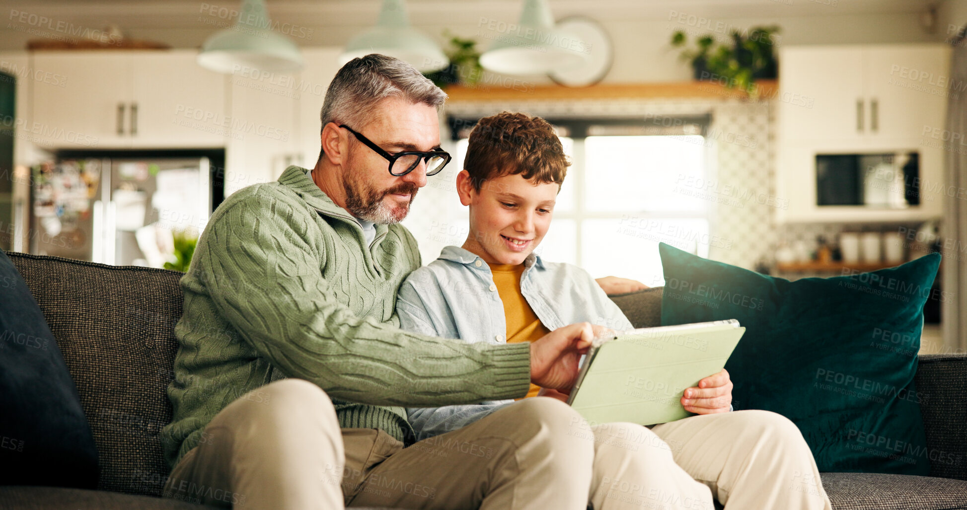 Buy stock photo Home, father and son with tablet, help and bonding together with online game, entertainment and smile. Learning, family and dad on couch, boy and parent with technology, social media and digital app