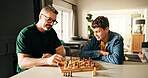 Playing, bonding and father with child for chess in home for learning, development or competition. Teaching, smile and dad with boy kid for board game with checkmate for problem solving skills.