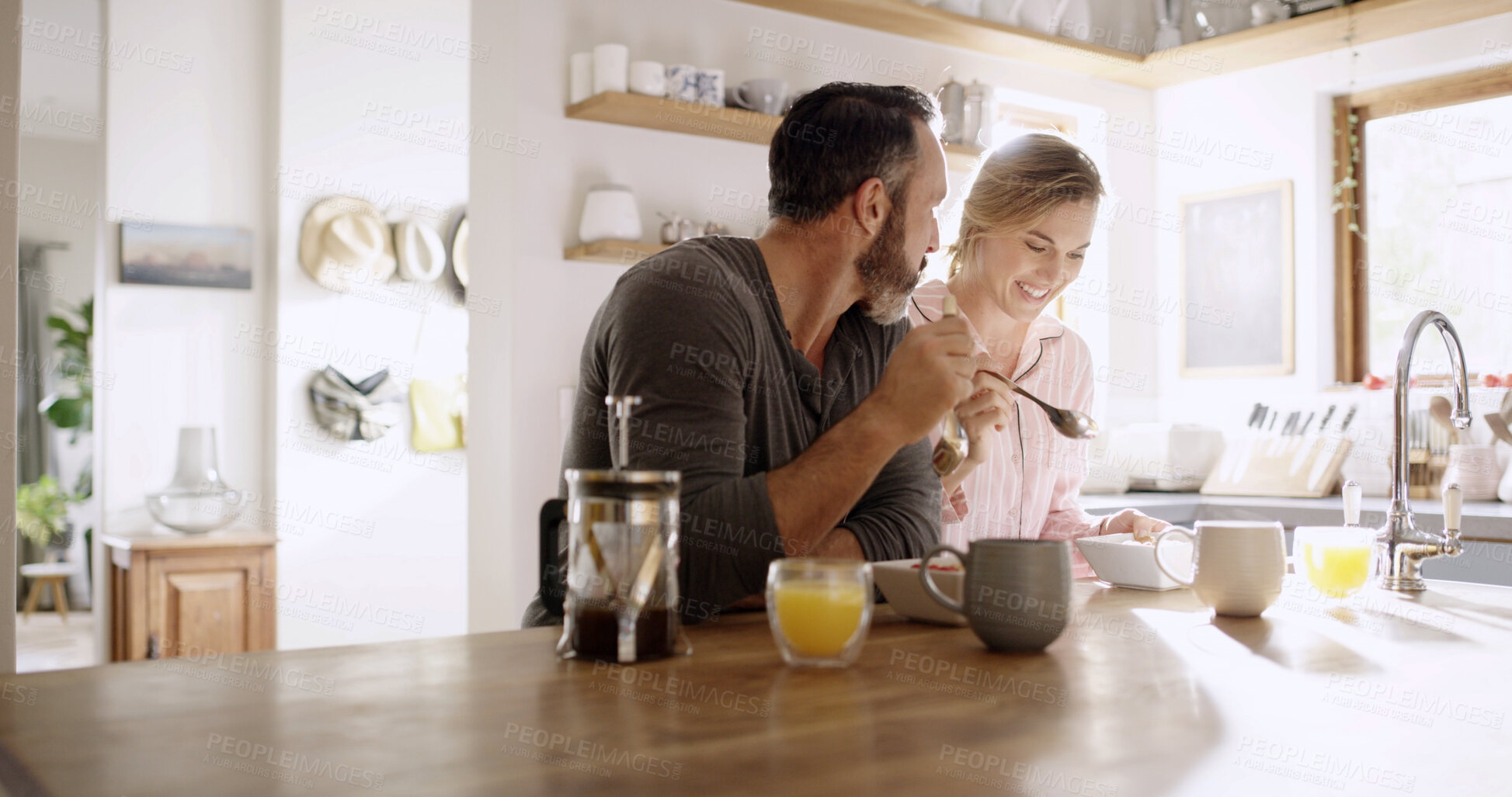 Buy stock photo Happy, couple and eating breakfast in kitchen for health, nutrition and diet with partner. Hungry, man and woman with morning meal, cereal and enjoy food together with conversation for love in home