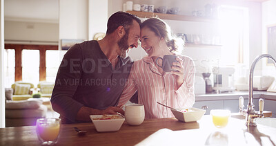 Buy stock photo Happy couple, laugh and drinking coffee in kitchen for health, nutrition and diet. Funny, man and woman with morning tea, breakfast cereal and bonding together with forehead touch for love in home