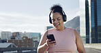 Phone, fitness and woman with headphones in city to listen to music, audio and workout playlist. Town, runner and happy person on smartphone for health app, exercise or radio for training outdoor
