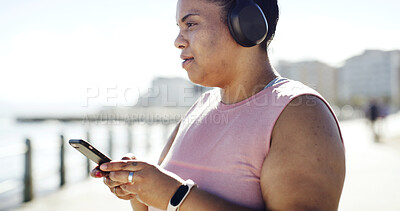 Buy stock photo Phone, headphones and woman on promenade with music, podcast or plus size for running exercise. Sports, audio and female athlete with cellphone for radio, cardio and workout outdoor for weight loss