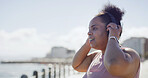 Woman, beach and headphones for fitness with smile, space for wellness with radio and health with sport outdoor. Female person, exercise and listening to podcast for training or workout on promenade